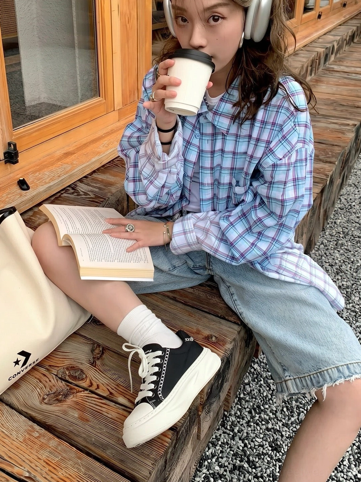 Black chain-trim platform sneakers worn with white socks, denim shorts, and a plaid shirt in a casual Korean-inspired outdoor outfit