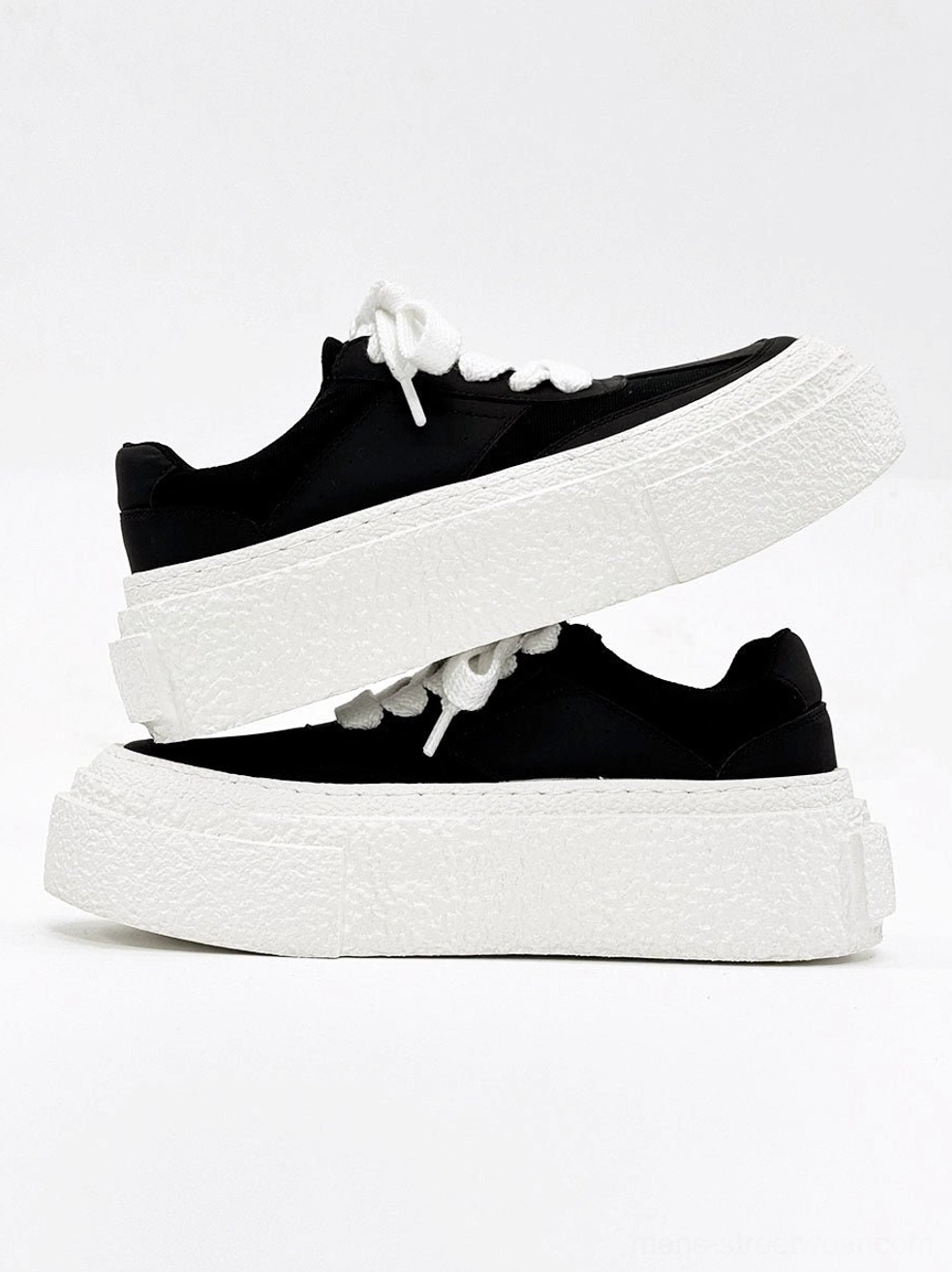 Pair of black chunky lace-up sneakers with stacked white textured rubber platform soles product view
