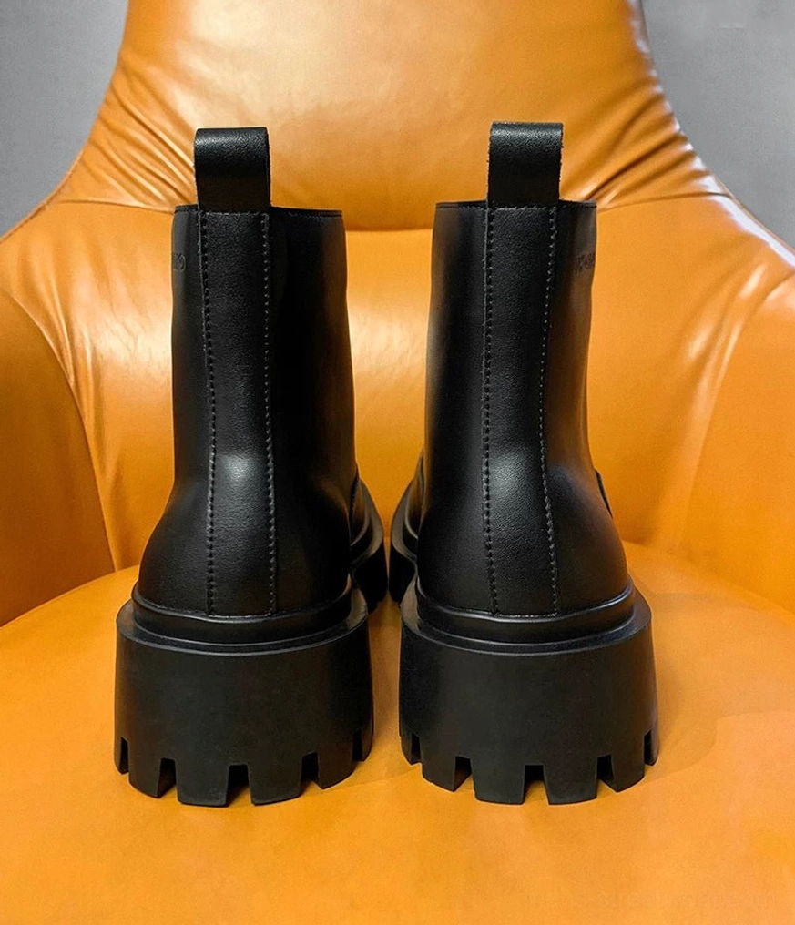 Black chunky lug sole boots with an elevated platform, front zipper closure, and modern avant-garde streetwear design