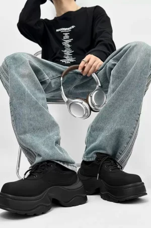 Male model wearing black chunky platform derby sneakers with light blue baggy jeans in a casual Seoul streetwear outfit