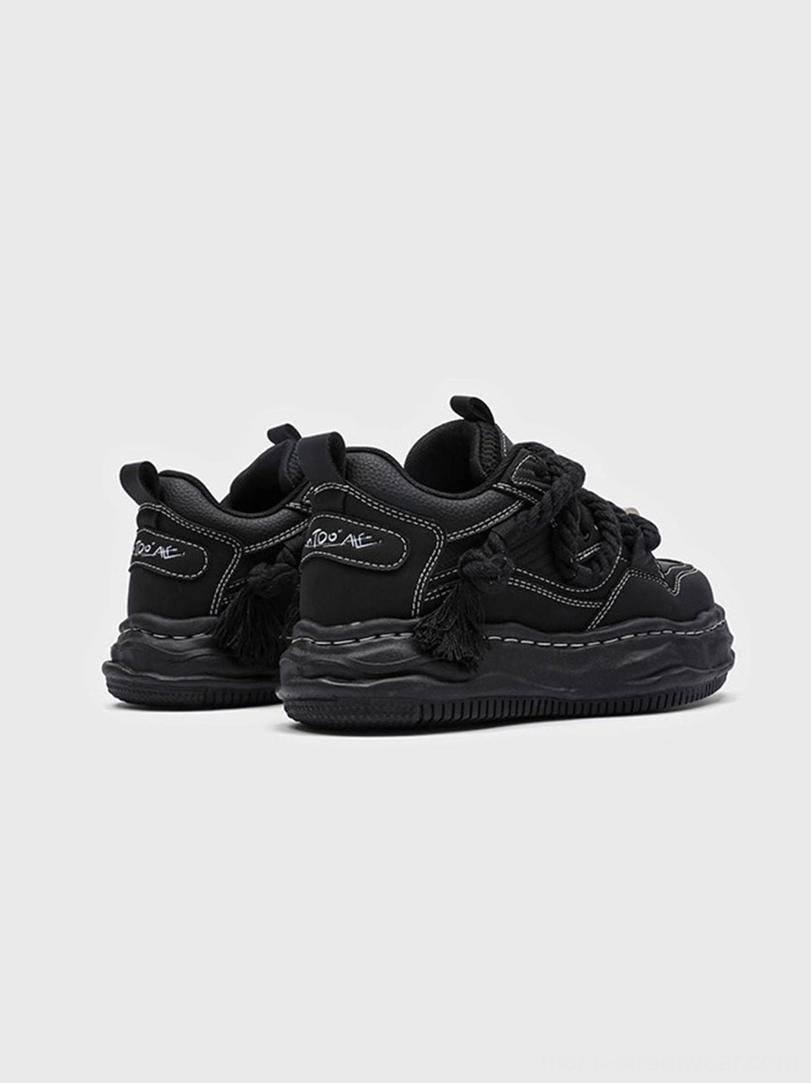 Black chunky platform sneakers with a distorted wave outsole and bold monochrome design for Korean and East Asian streetwear outfits