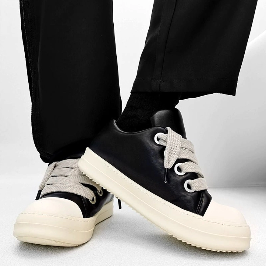 Side view of black chunky platform sneakers showing silver metal eyelets, matte microfiber leather upper, wide laces, and ridged rubber outsole
