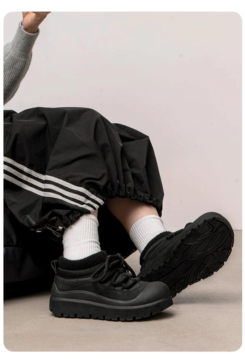 Black chunky platform sneakers worn with striped track pants and white crew socks in a low-angle Korean streetwear outfit