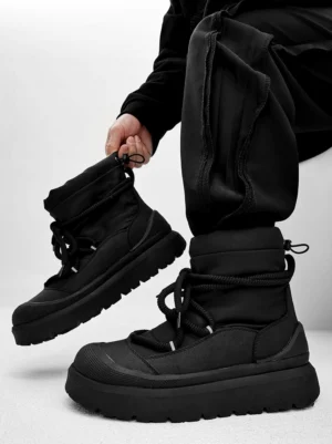 Black chunky platform winter boots worn with black cargo pants in an overhead streetwear outfit view