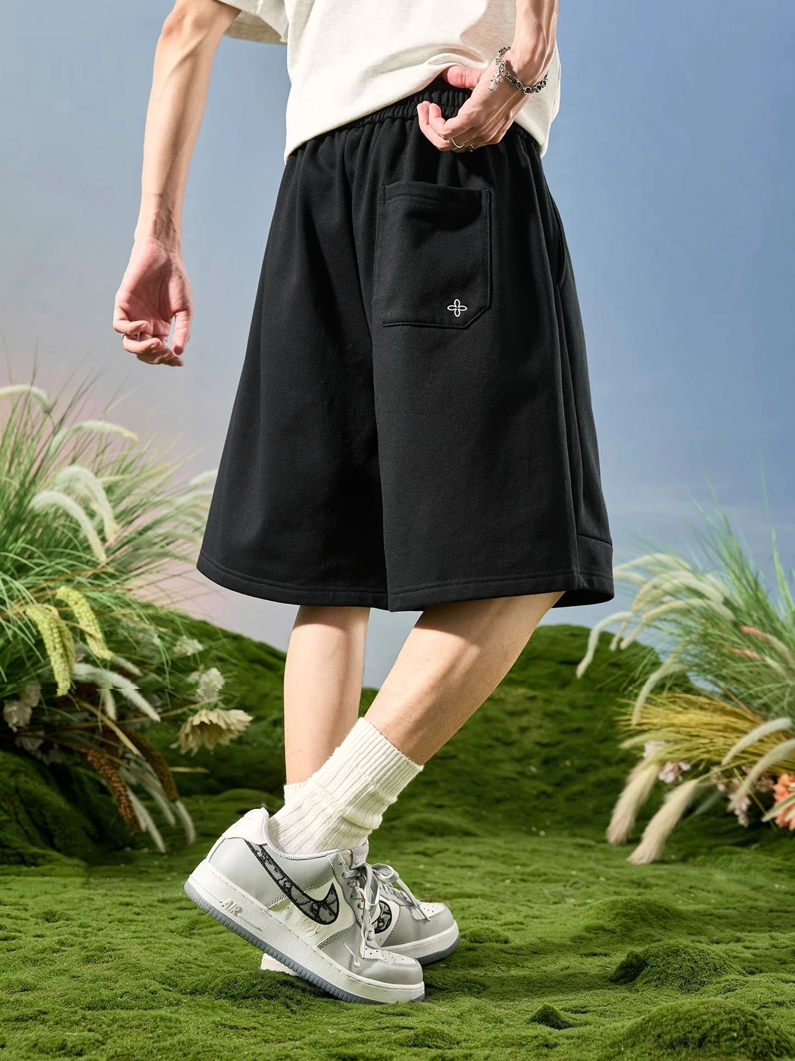 Black cloud fleece drawstring lounge shorts shown from the rear with a relaxed wide-leg silhouette and back patch pocket in a Korean streetwear outfit