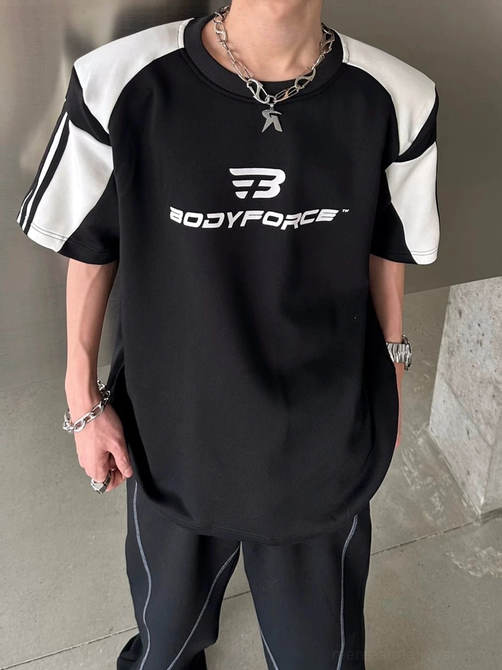 Black colorblock sport tee with varsity sleeve stripes and relaxed streetwear fit