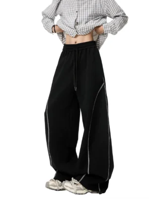 Black oversized contrast stitch balloon sweatpants front view showing drawstring elastic waistband and extra wide streetwear legs