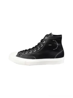 Black contrast-stitch platform high-top sneaker shown from the side with white rubber toe cap, thick sole, metal eyelets, and structured streetwear silhouette