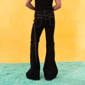 Rear view of black flared jeans with white contrast stitching back pockets and hanging side strap