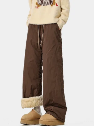 Black crinkle nylon convertible fleece-lined wide-leg pants low-angle front view with off-white shearling cuffs revealed and fuzzy cropped sweater
