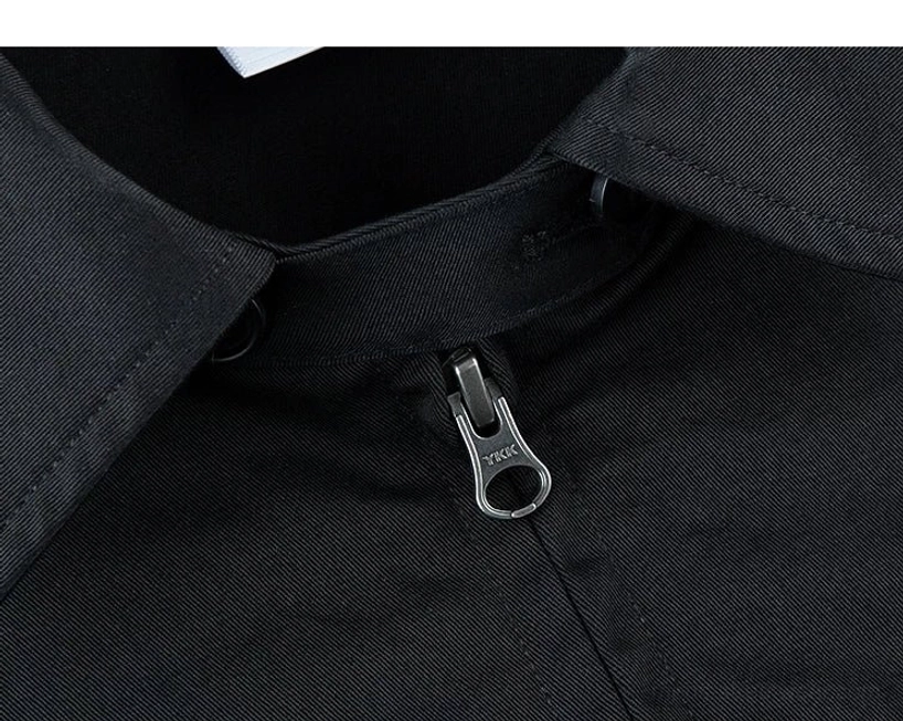 Close-up of solid black cotton twill Harrington jacket collar, metal zipper puller, collar button, and precise stitching