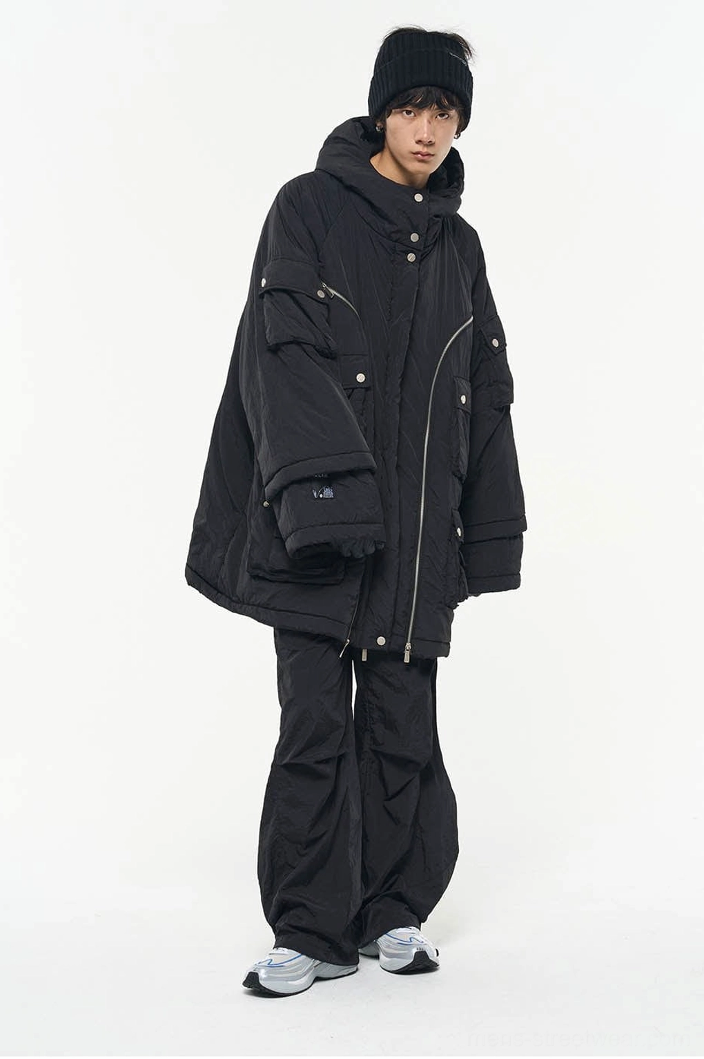 Black crinkled nylon wide-leg track pants paired with an oversized zip-up jacket and sport sneakers