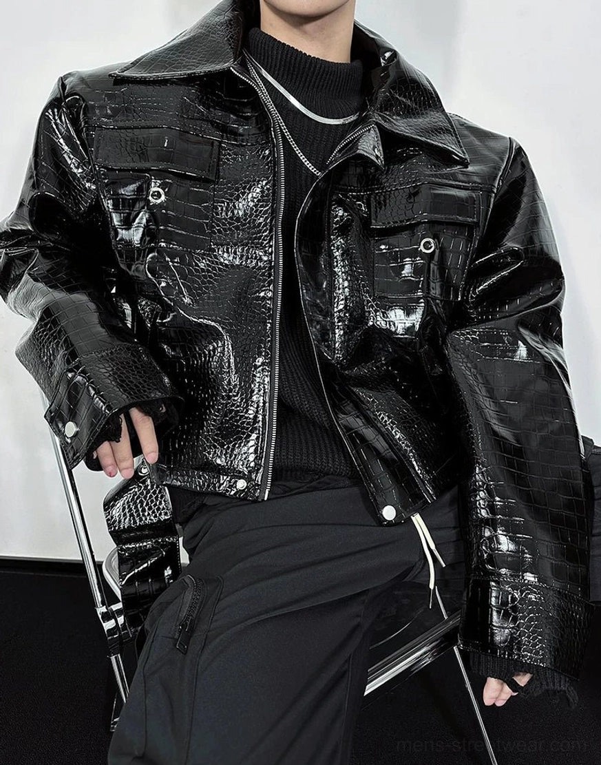 Close-up front view of black croc embossed moto jacket featuring metal pocket snaps and glossy faux leather texture
