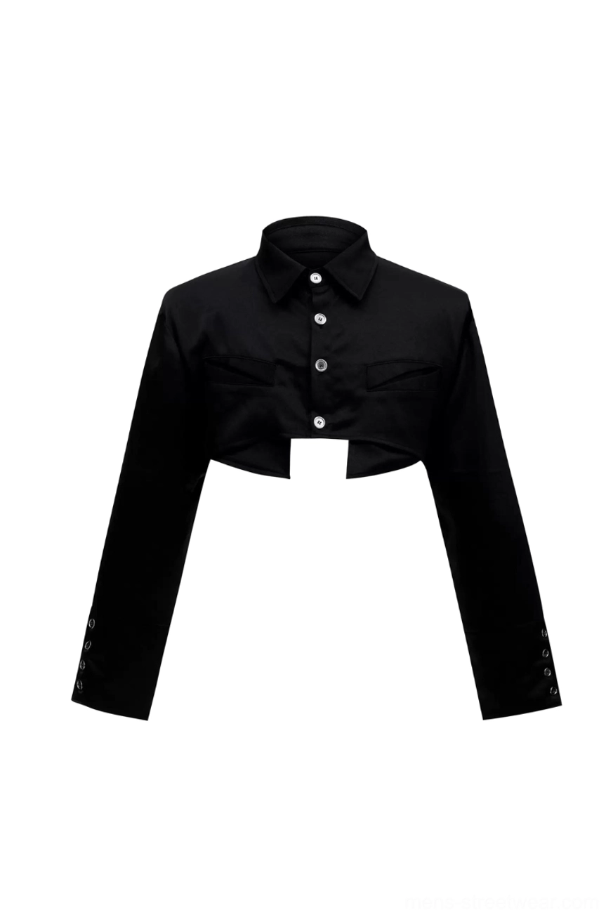 Flat lay black cropped button-down shirt with pointed collar, two chest patch pockets, metal buttons, and decorative snap cuffs