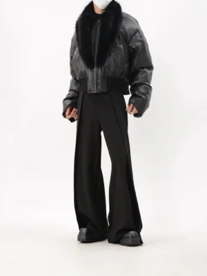 Three-quarter rear view of a black cropped faux leather puffer jacket showing dropped shoulders, oversized puff sleeves, streamlined back, and ribbed hem