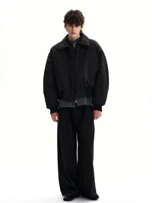 Full body view of black cropped padded bomber jacket with hidden zipper black wide leg trousers and leather shoes
