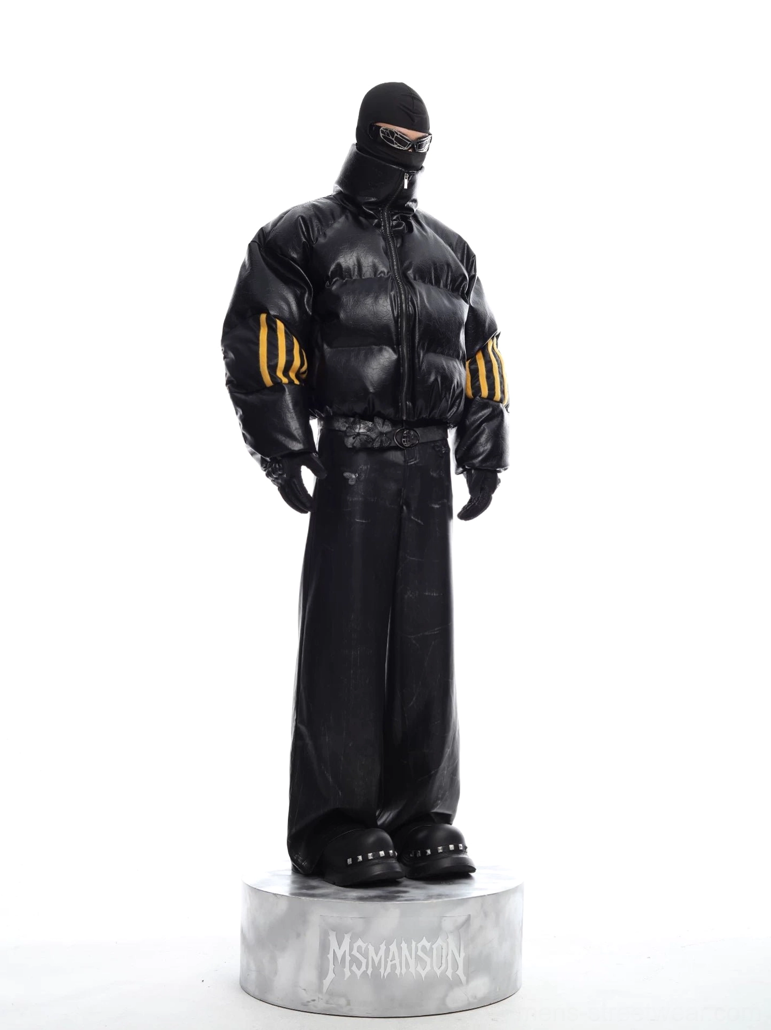 Full body side view of black cropped puffer jacket with matching wide leg pants, yellow sleeve stripes, gloves, and futuristic techwear styling