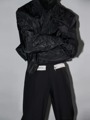 Black cropped quilted utility jacket back three-quarter view styled with black wide-leg streetwear pants