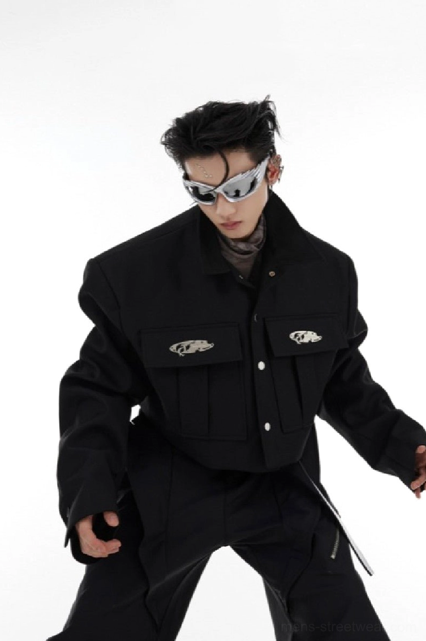 Black cropped shoulder pad cargo jacket worn by male model in white studio front three-quarter view with structured shoulders and flap chest pockets