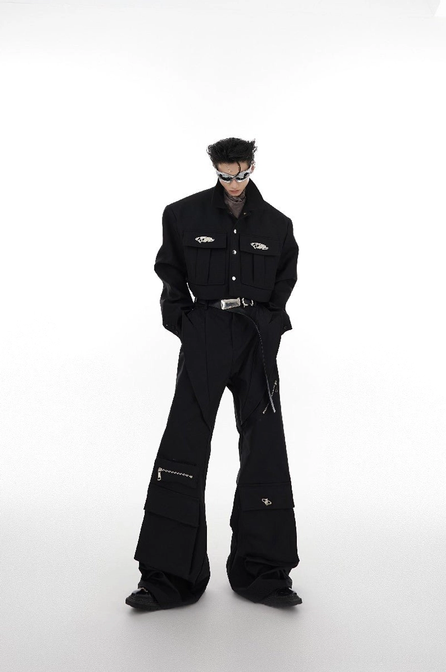 Full body black cropped shoulder pad jacket outfit with wide-leg cargo pants and silver sunglasses in white studio