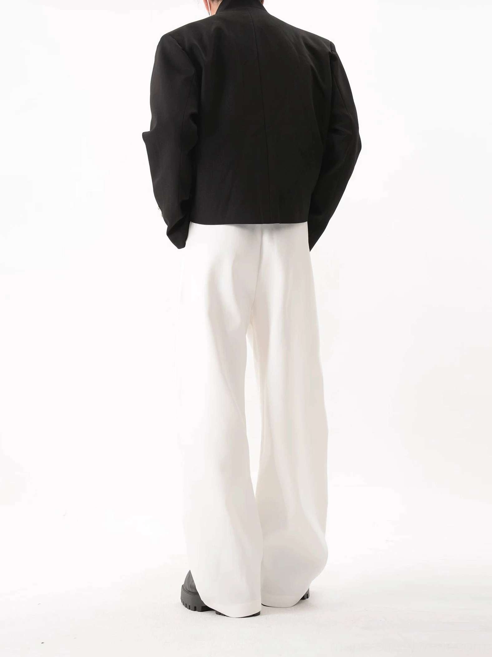 Rear view of black cropped stand collar blazer showing clean back panel structured shoulders and short tailored hem