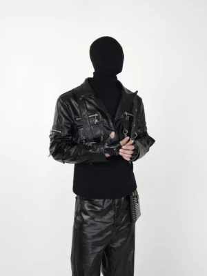 Black cropped tactical biker jacket worn with black turtleneck showing lapel collar metal zippers and fitted long sleeves