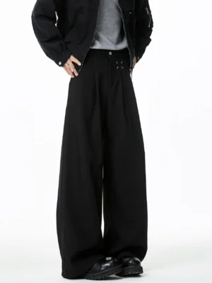 Low angle front view of black cross stitch pleated wide leg streetwear trousers with a high waist and floor length draped hem