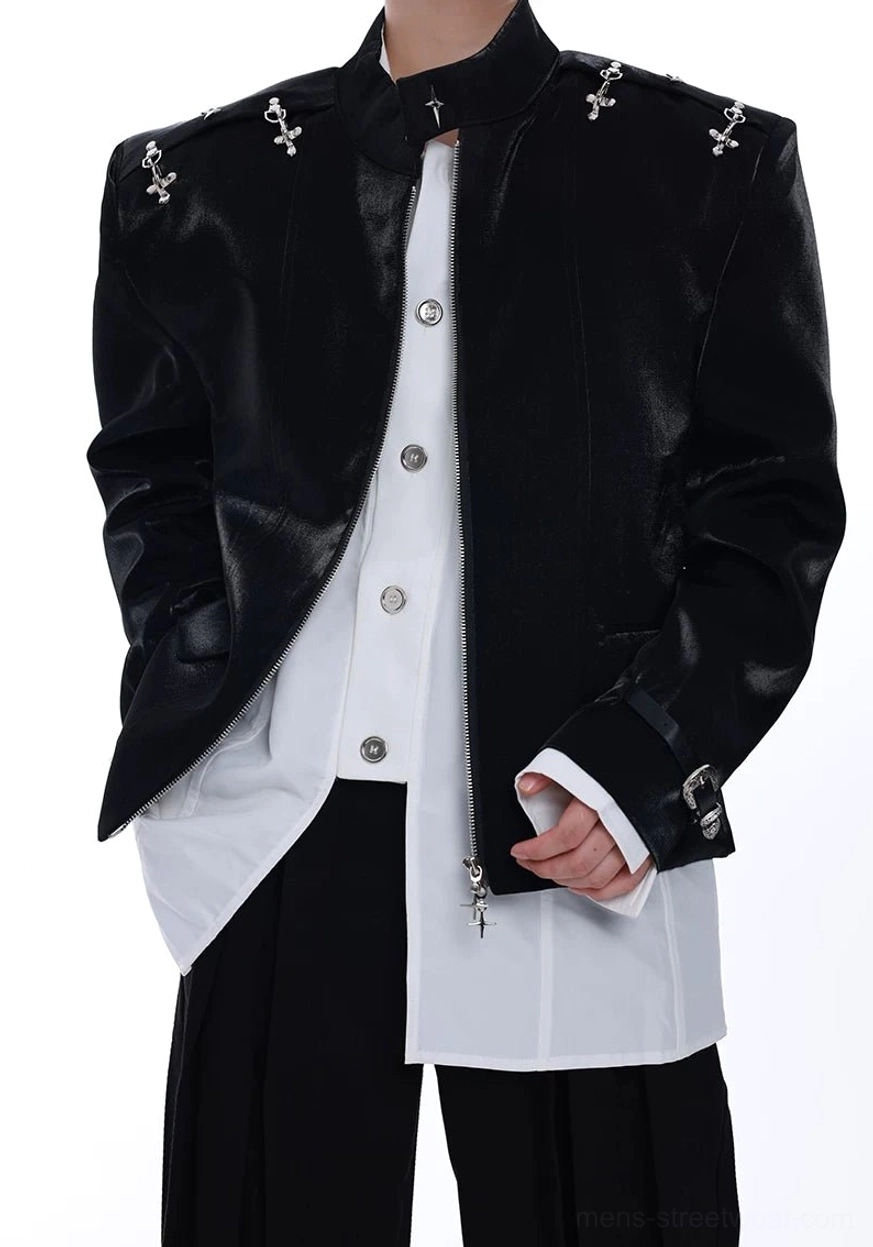 Close-up of a black cross-stud leather blazer showing the stand collar, silver shoulder decorations, front closure, and layered shirt styling