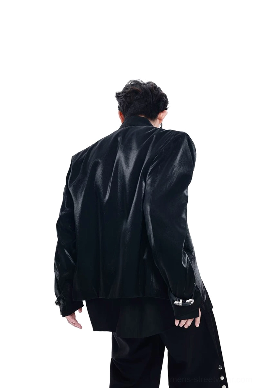 Back view of a glossy black cross-studded leather blazer showing the seamless rear design, structured shoulders, and futuristic gothic silhouette