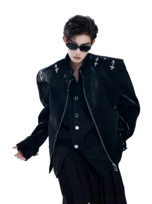 Front three-quarter view of a black patent leather gothic punk blazer with sharp padded shoulders, silver cross studs, stand collar, and futuristic streetwear styling