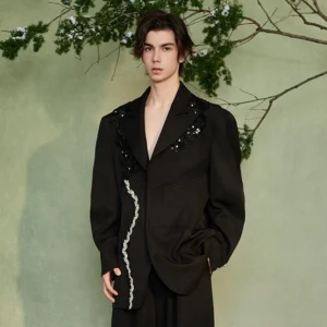 Three-quarter view of a relaxed black crystal embellished streetwear blazer with oversized notched lapels and front pockets