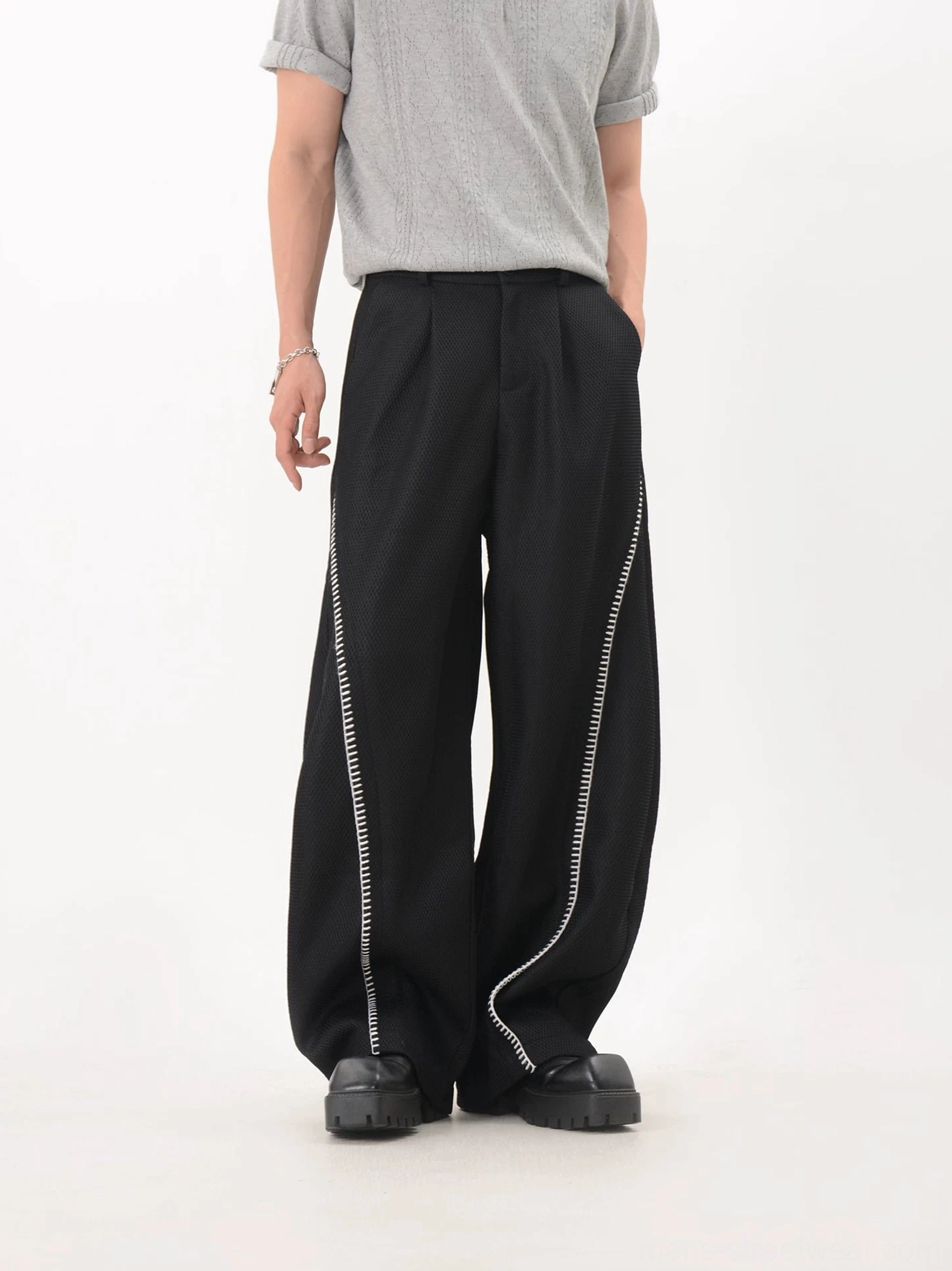 Black curve trim mesh texture wide leg techwear trousers front low angle view with white contrast side detailing