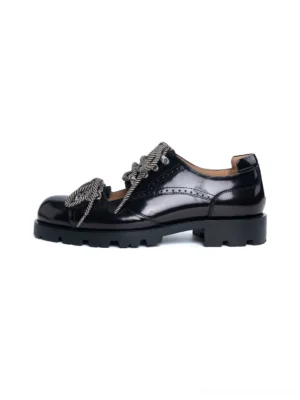 Black cutout platform workwear derby shoes with glossy patent-style upper, braided laces, brogue details and serrated chunky sole side view