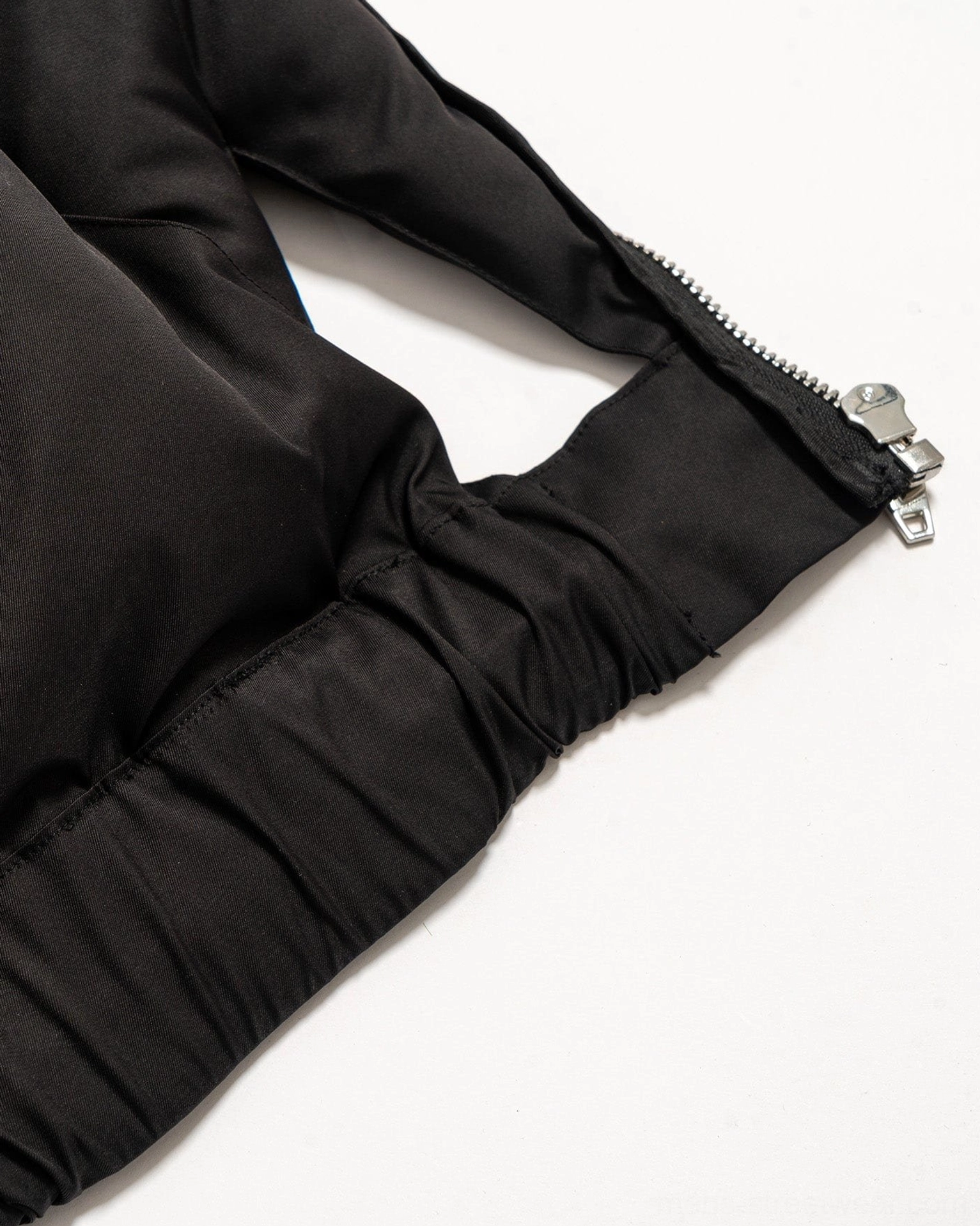 Black avant-garde cutout puffer vest image showing a compact cropped silhouette and sleeveless techwear construction