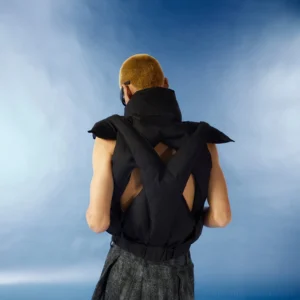 Black cropped puffer vest back view showing crisscross open cutout design padded panels high collar and elasticated hem