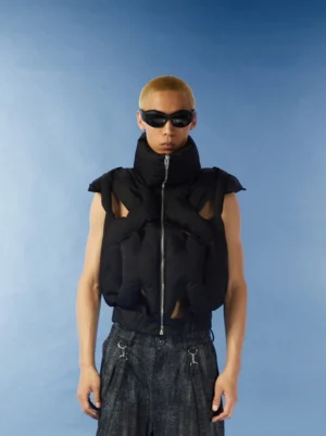 Black cropped cutout puffer vest front view on male model with high stand collar front zipper and quilted padded streetwear texture