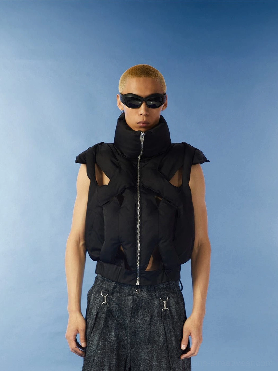 Black cropped cutout puffer vest front view on male model with high stand collar front zipper and quilted padded streetwear texture