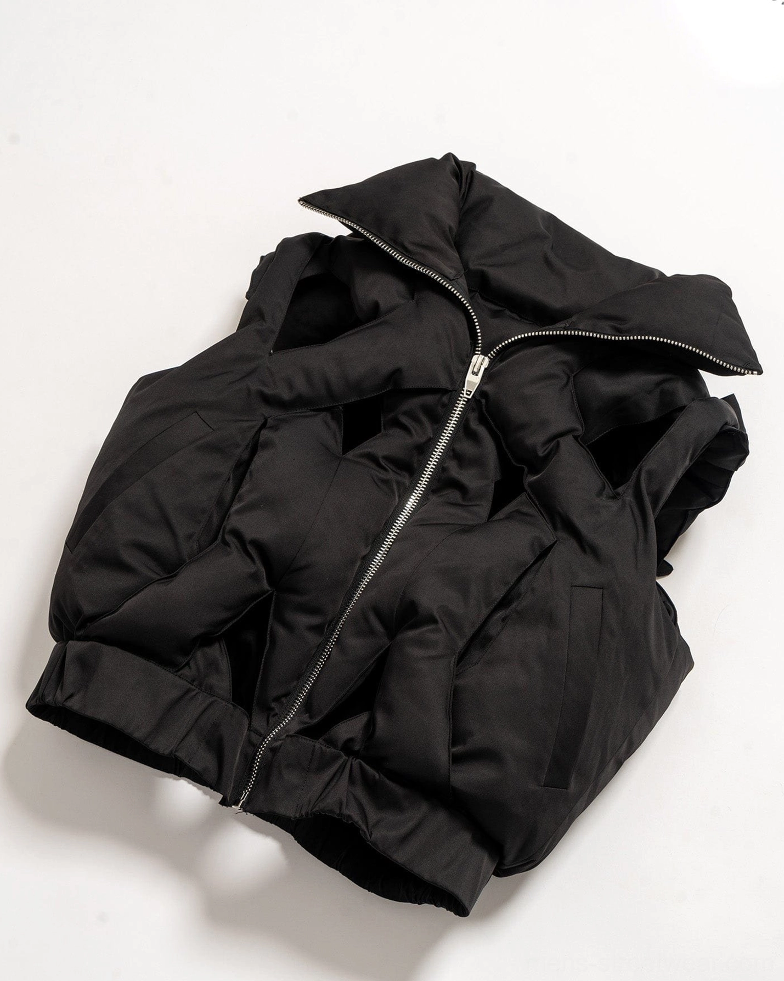 Black cutout puffer vest style image featuring high stand collar front zipper and modern layered outerwear profile