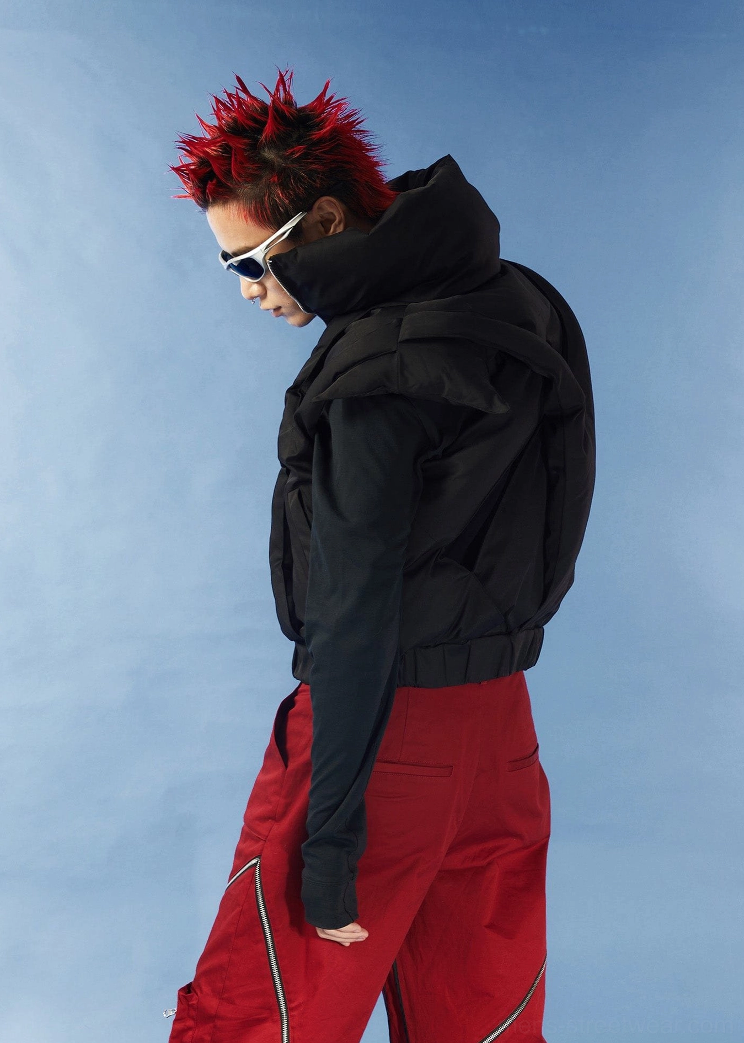 Side view of sleeveless black padded cutout vest with cropped hem fitted waist and futuristic techwear silhouette
