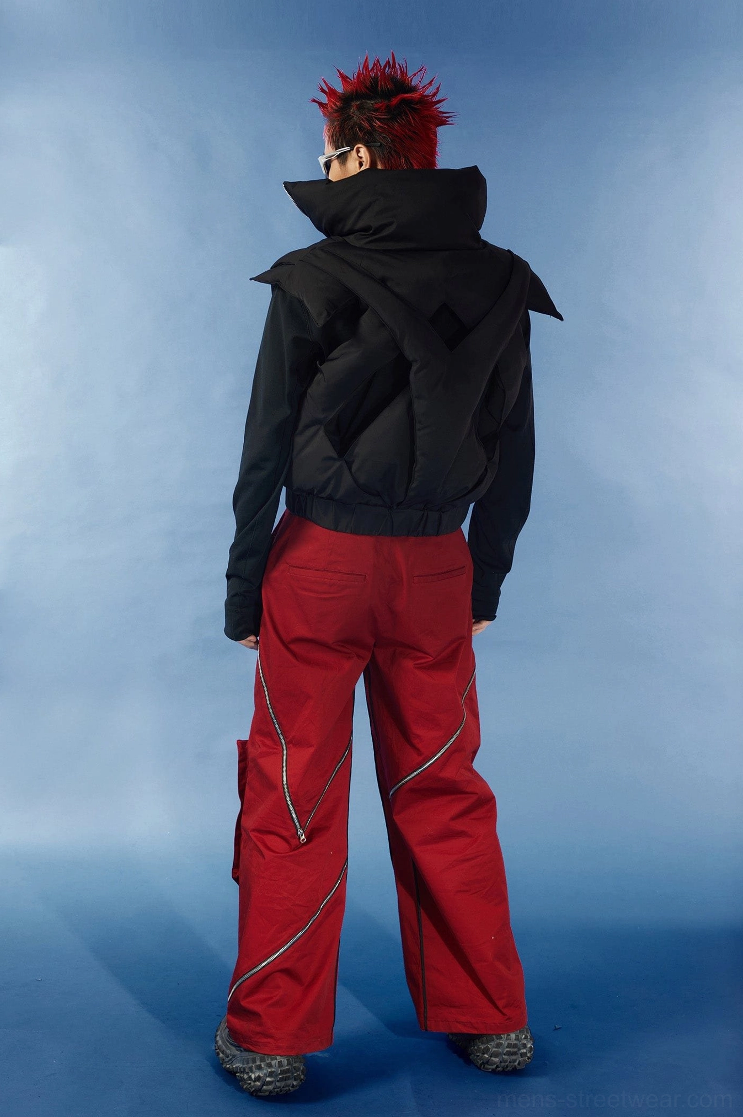 Black techwear inspired cutout puffer vest with front zip closure cropped length and dimensional padded texture