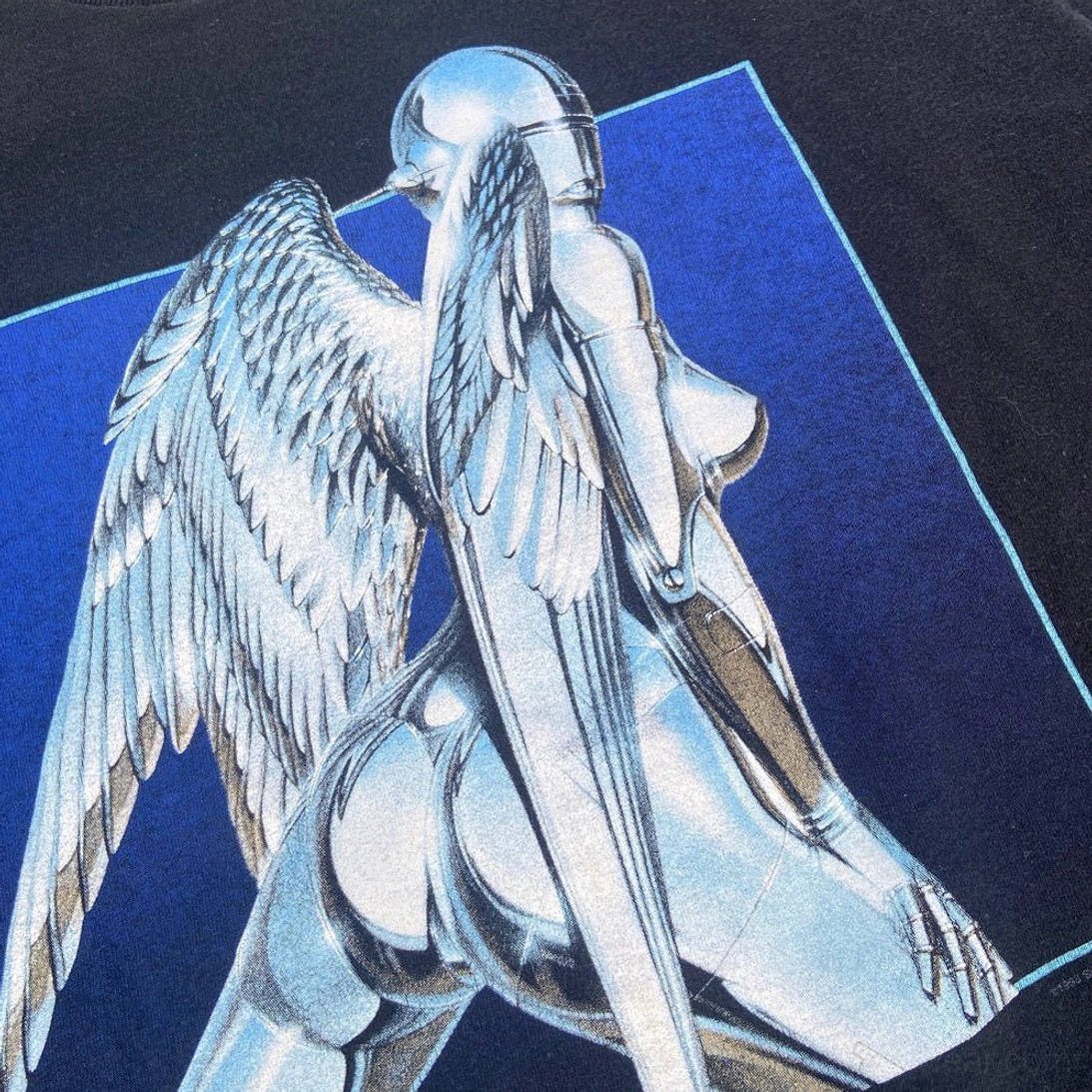 Close-up of silver chrome cybernetic angel graphic with feathered wings and deep blue framed background on black streetwear t-shirt