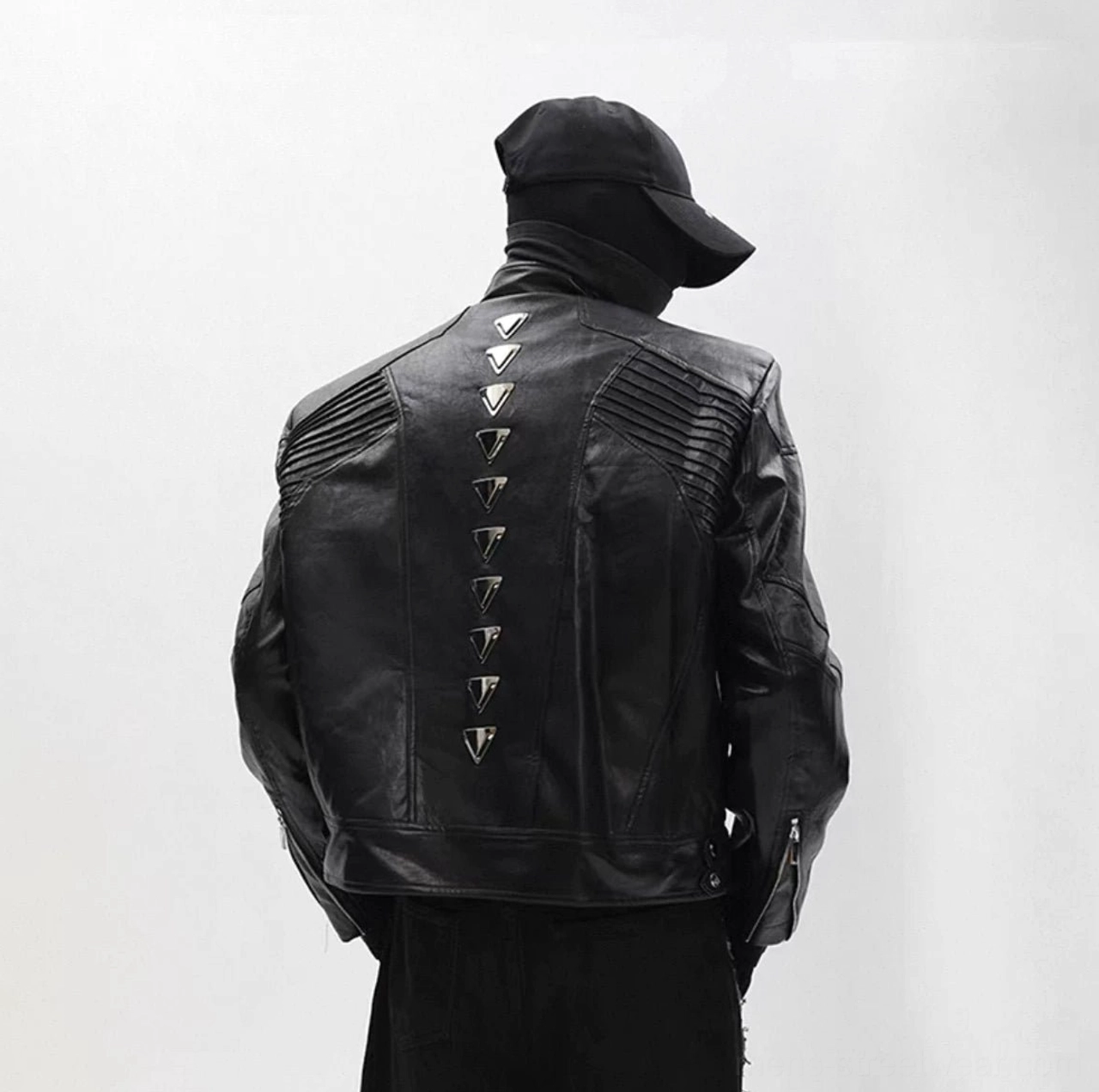 Black cyberpunk studded moto jacket close-up showing faux leather texture quilted shoulders and metal spine studs
