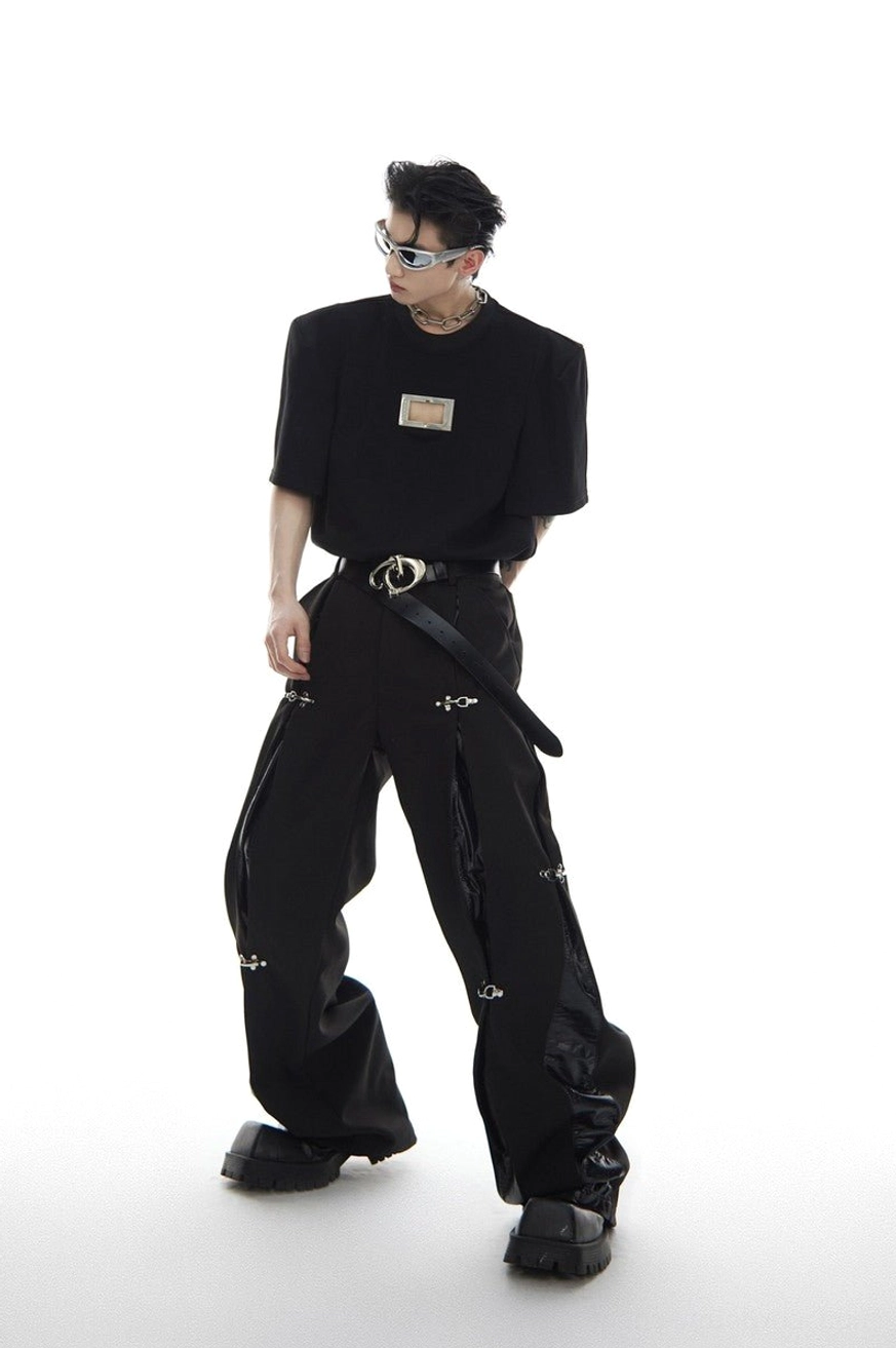 Full outfit view of black deconstructed buckle wide-leg trousers styled with cropped top platform boots and silver accessories