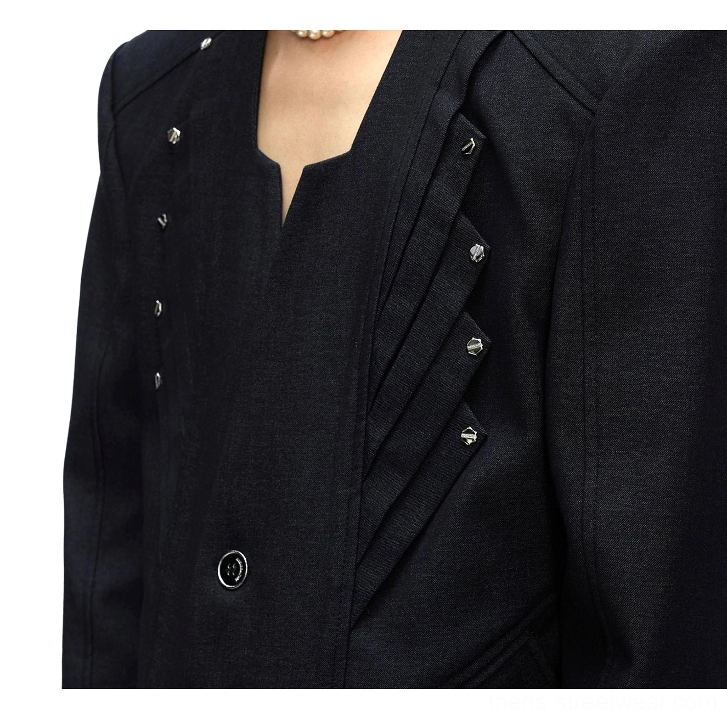 Close-up of black deconstructed oversized blazer with pleated chest accents metal studs and notched lapel