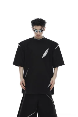Black oversized deconstructed loose fit tee with padded shoulders diagonal mesh cutouts and asymmetric details styled as futuristic Korean techwear streetwear
