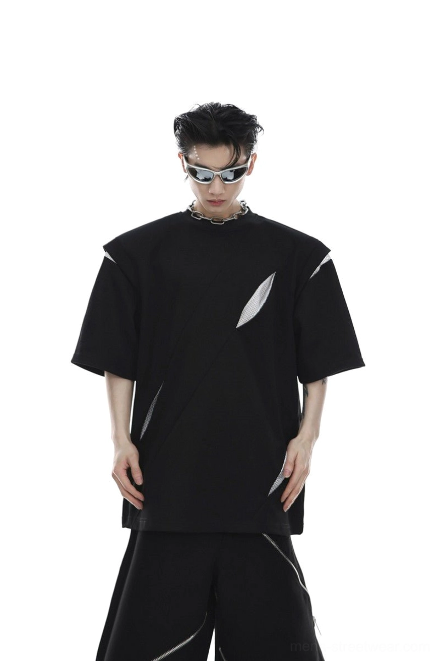 Black oversized deconstructed loose fit tee with padded shoulders diagonal mesh cutouts and asymmetric details styled as futuristic Korean techwear streetwear