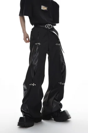 Black oversized wide-leg trousers with deconstructed glossy side panels and silver buckle clips three-quarter front view