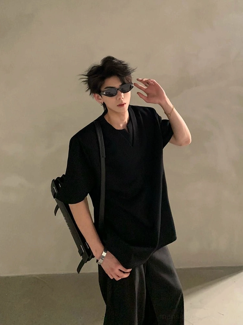 Black deep V notched neck shirt styled with black wide leg trousers and a backpack in a modern streetwear outfit