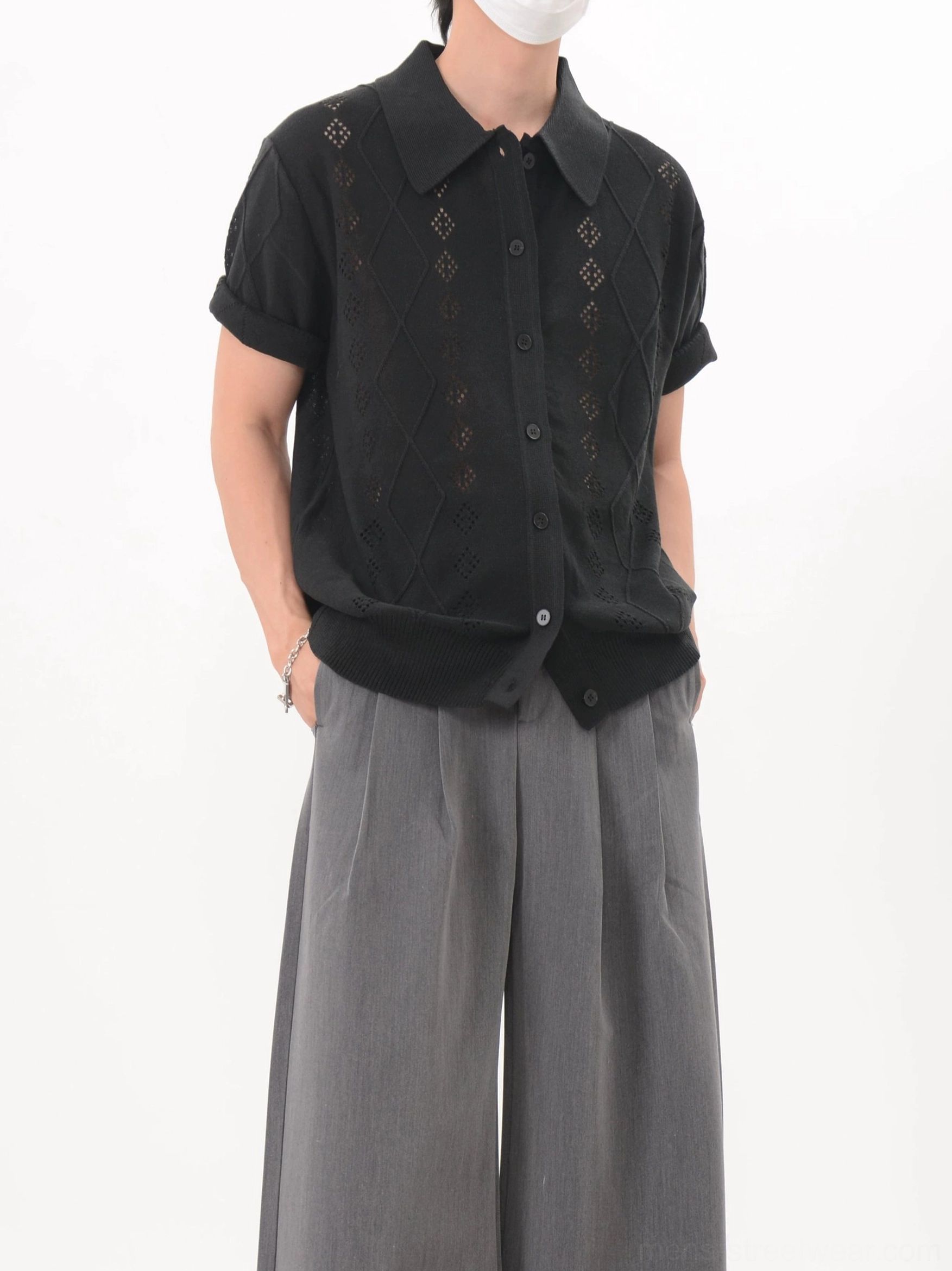 Black diamond eyelet knit polo cardigan shown from the side with a casual turn-down collar and rolled sleeves