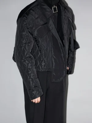 Black diamond quilted cropped utility jacket side profile with flap pockets and silver hardware